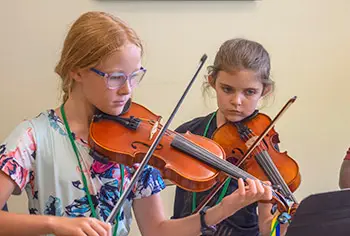 Two girls playing violins