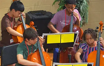 4 students playing cellos