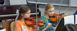 2 girls playing violins