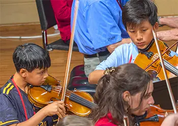 2 boys playing violins