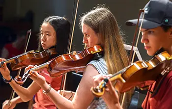 3 young people playing violins